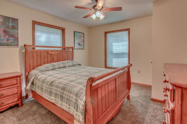 A bed, with a night stand to the left and a cupboard in front of the foot of the bed. A bed, with a night stand to the left and a cupboard in front of the foot of the bed.