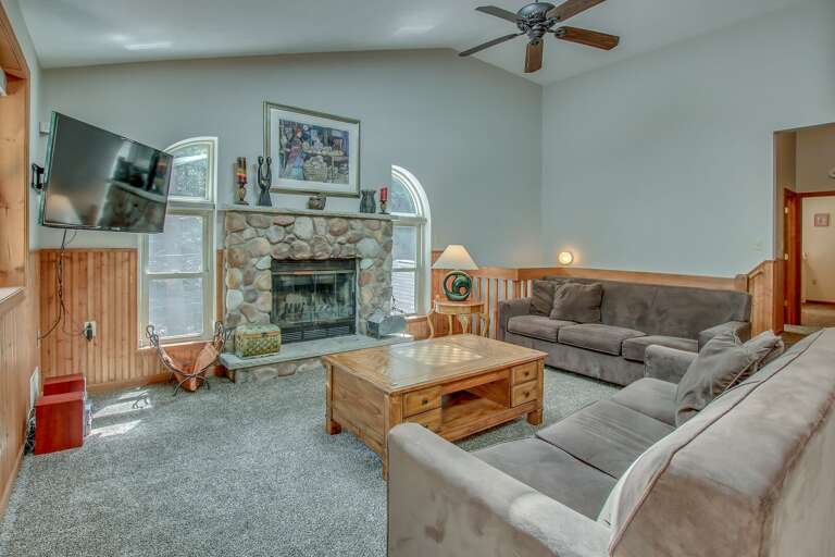 The living room, with two couches, a fireplace, TV, and a coffee table in the center of the room. The living room, with two couches, a fireplace, TV, and a coffee table in the center of the room.