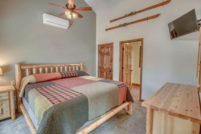 Bedroom with Ski Wall Art, Flat Screen TV, And Rustic Decor