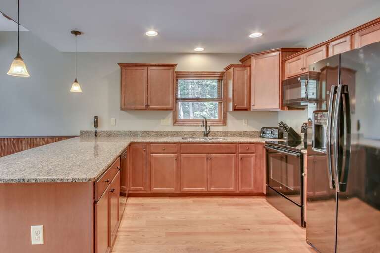 Luxury Kitchen with Fridge, Stove, and Expansive Counter Space
