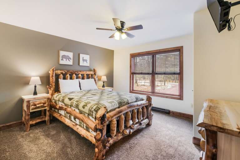 Bedroom with Log Bed, Mounted TV and Wood Dresser