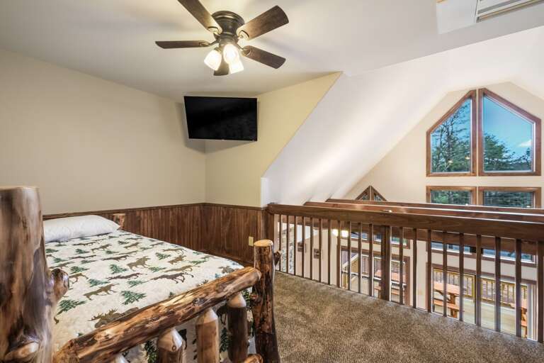 Loft Area with Mounted TV, Bed, and View of Great Room