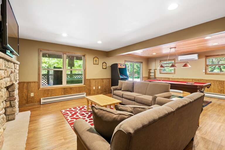 basement with two sofas and an arcade cabinet