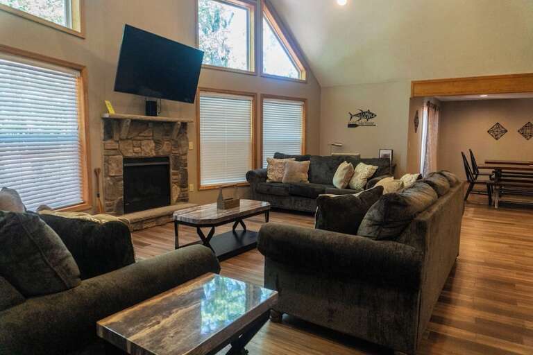 Living Room With Large Sofa, Hardwood Floors, And Stone Fireplace