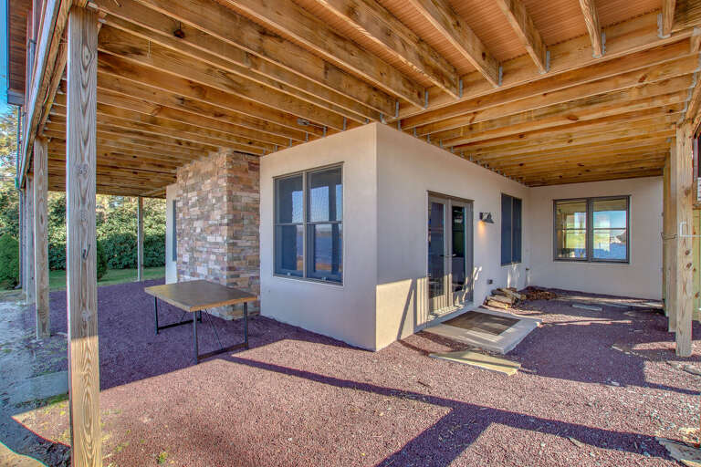 Underneath the second floor porch of this Poconos rental by the lake, with table and room for cars.