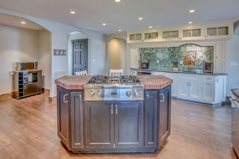 The island of the kitchen, with stove top range and microwave in shot.