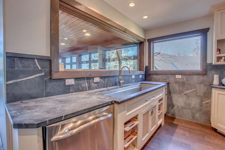 Kitchen sink with window into the dining room, and dishwasher in the bottom left.