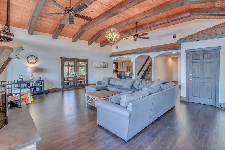 The sectional couch, coffee table, and arched entryways leading out from the great room.