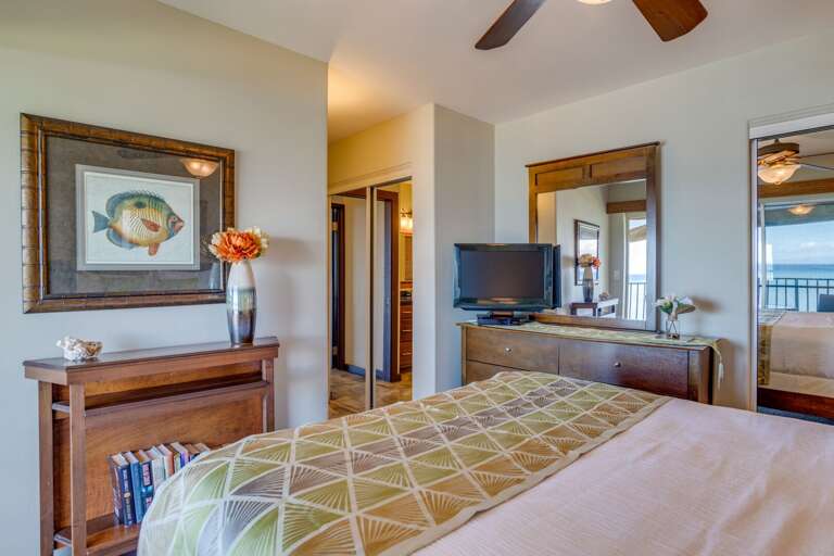 The second master bedroom has a television and a sliding door to the balcony.