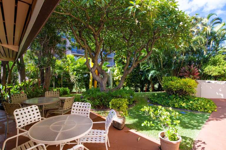 Relax poolside with shaded tables.