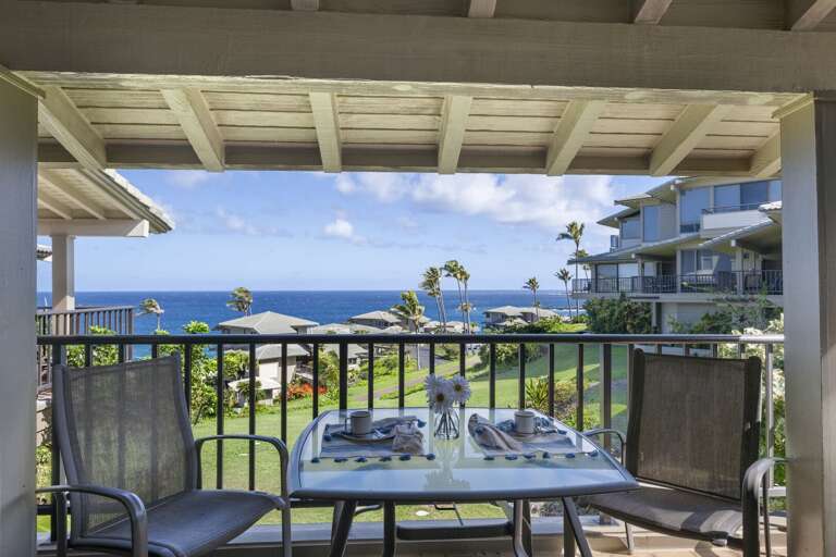 Balcony View With Blue Ocean Backdrop, Breezy Palms And Laid Table