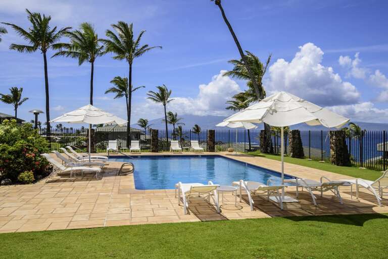 Pool offers umbrellas and lounge chairs with an ocean view