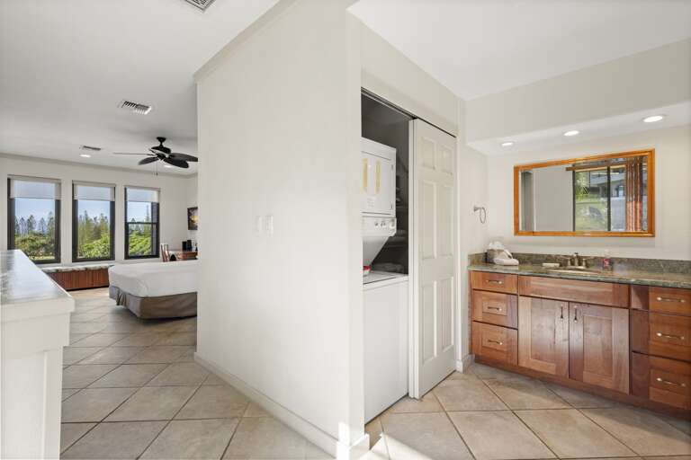 Stacked washer and dryer behind sliding doors in bathroom sink vanity area