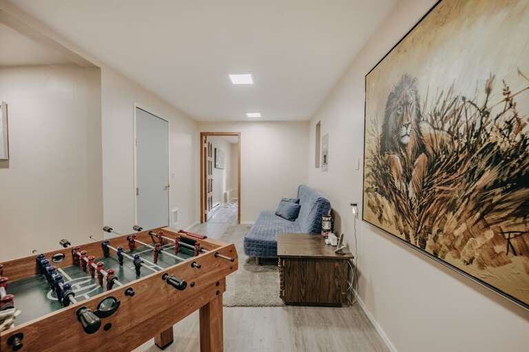 The sitting area on the lower level with foosball table and a futon The sitting area on the lower level with foosball table and a futon