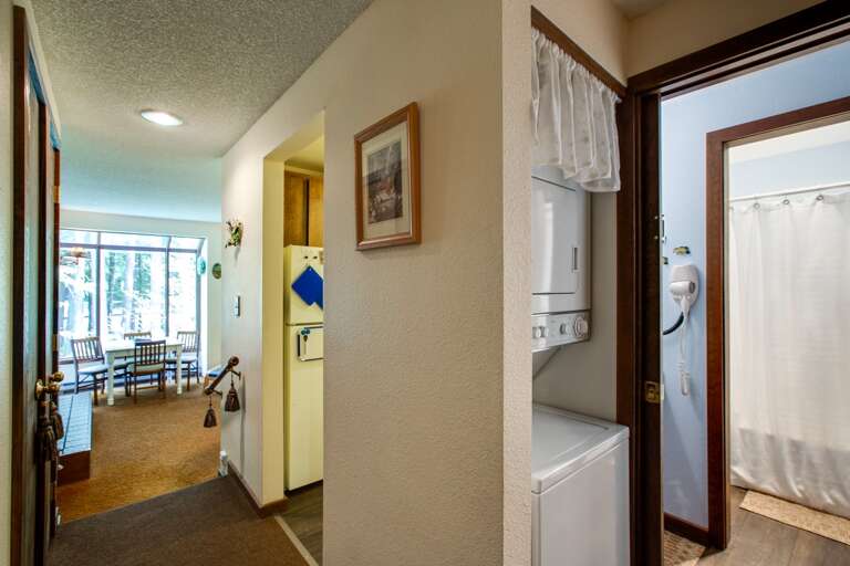Entry view of condo with hallway laundry area