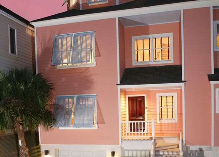 Pink Two-story House At Dusk With Illuminated Windows And Palm Tree Pink Two-story House At Dusk With Illuminated Windows And Palm Tree