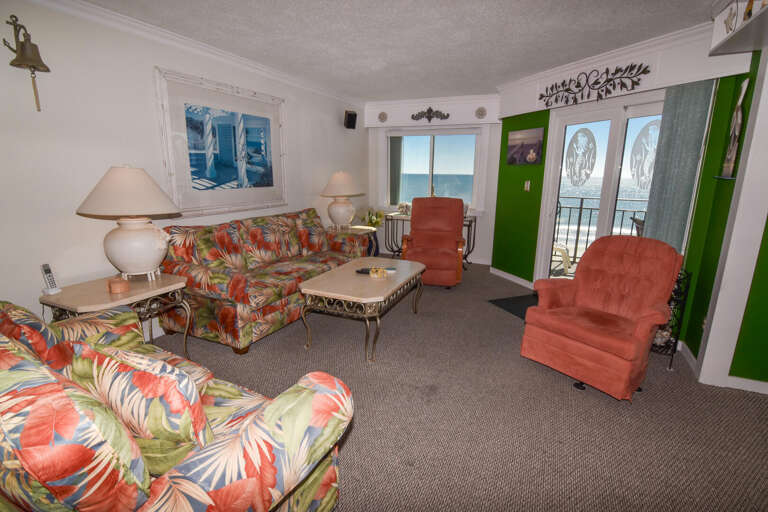 Beach-view Living Room With Patterned Sofas And Sliding Door To Balcony