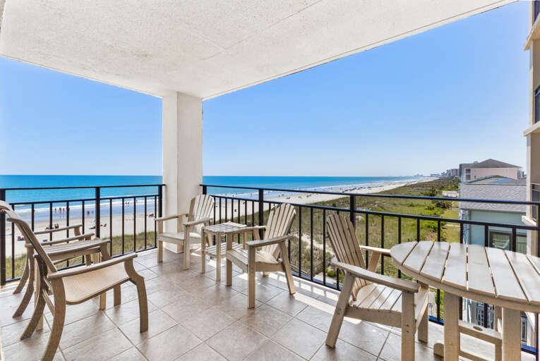 Balcony View Of Beach With Chairs, Clear Skies, And Sea
