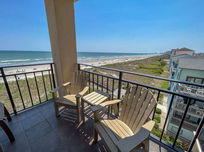 Balcony View Of Beach And Chairs Overlooking Ocean Waves