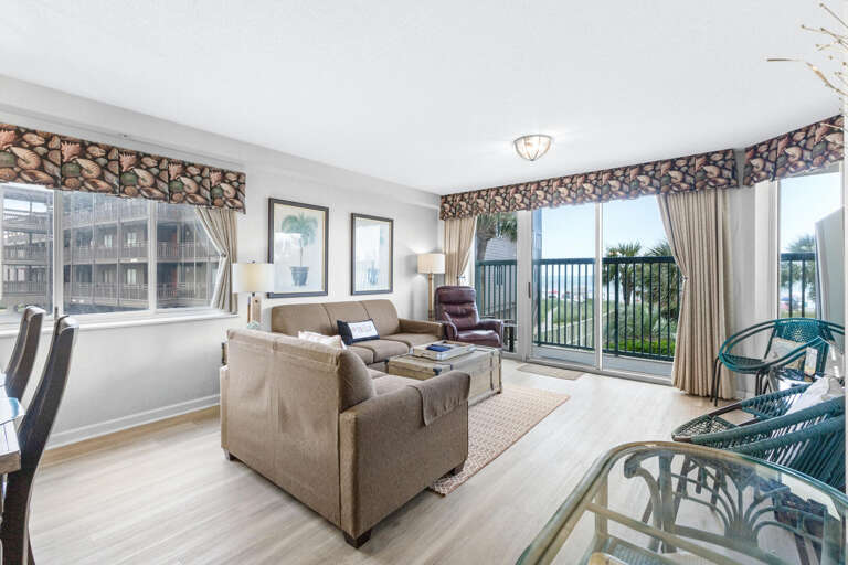 Lush Living Room With Large Windows And Glass Door To Balcony