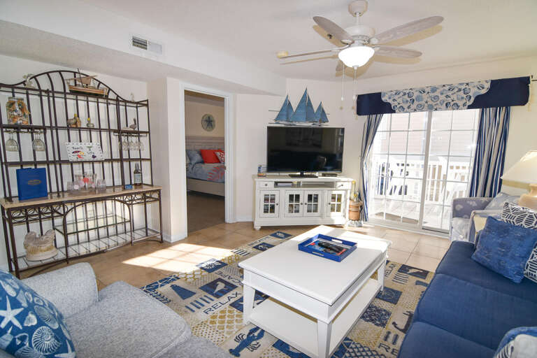 Bright, Breezy Living Room With Blue Accents And Balcony Access