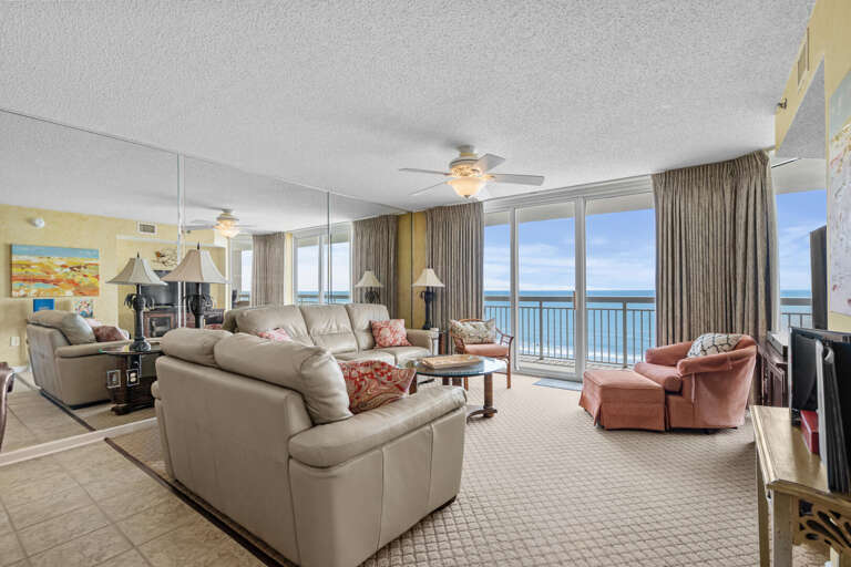 Seaside Living Space With Sofas Facing Large Windows Overlooking The Ocean