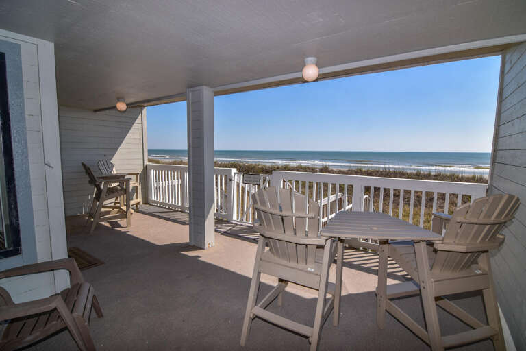 Wooden Chairs On Balcony Overlooking Beach