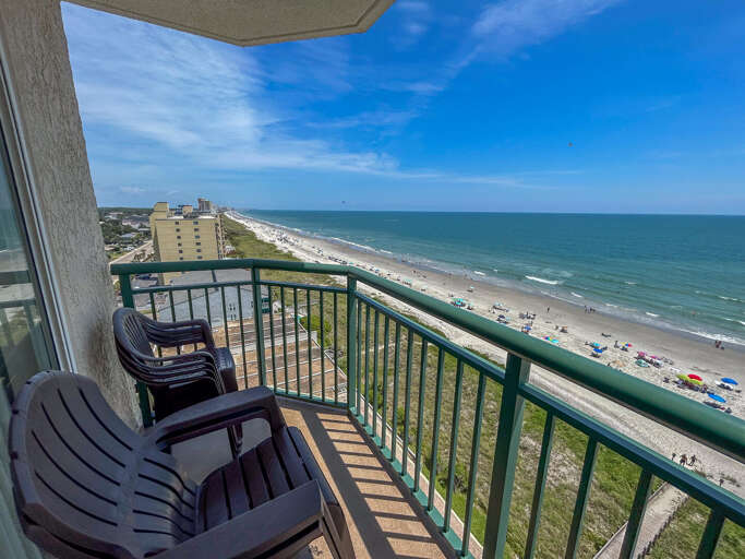 Balcony View Of Beach With Blue Sky And Bustling Shore