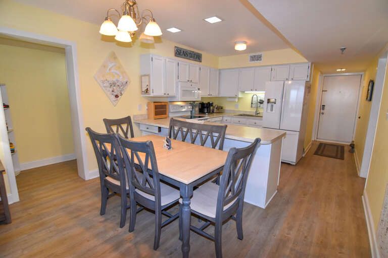 Spacious Kitchen And Dining Area With Light Wood Flooring And White Cabinets