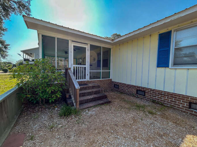 Blue-shuttered Building With A Screened Porch And Sunlit Setting