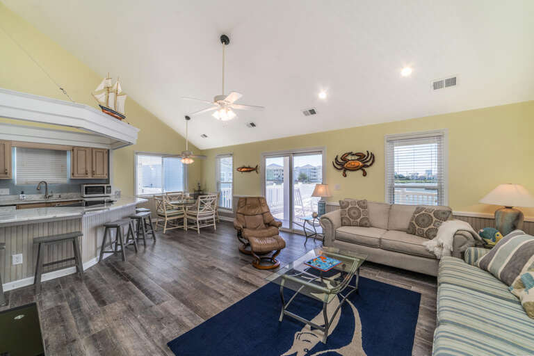 Spacious, Sunlit Living Area With Light Walls, Wooden Floors, And Breezy Decor