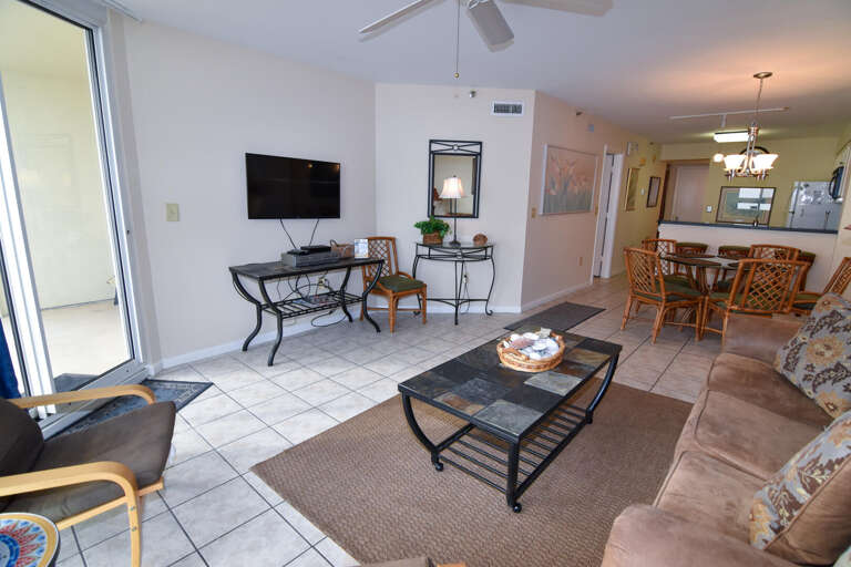 Interior View Showing Spacious Living Area With Sofas, Dining Set, And Sliding Glass Door