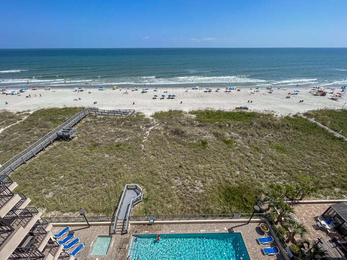 Aerial View Of Poolside Path Through Dunes To Busy Beach