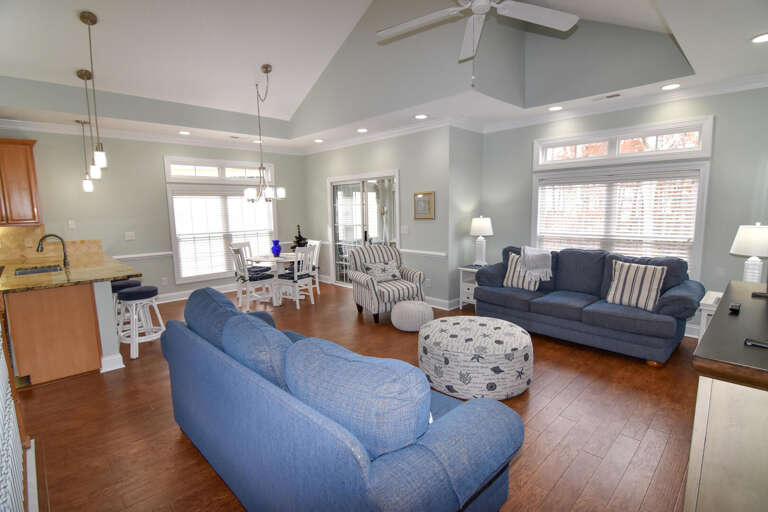 Spacious Living Space With Blue Sofas And White Bar Stools