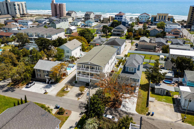 Aerial View Of A Vibrant Village With Various Residences Near The Beach