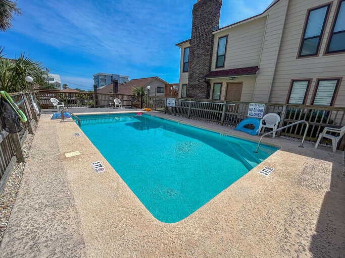 Blue Pool Between Brick Buildings Under Bright Sky