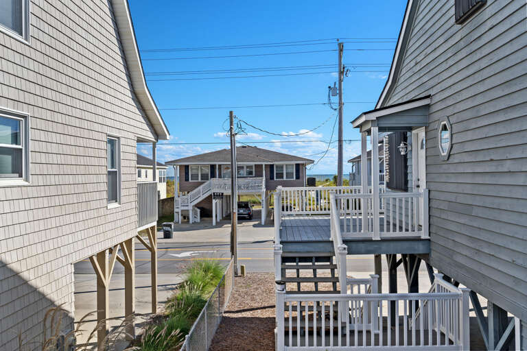 Wooden Buildings By The Beach With Balconies And Blue Skies