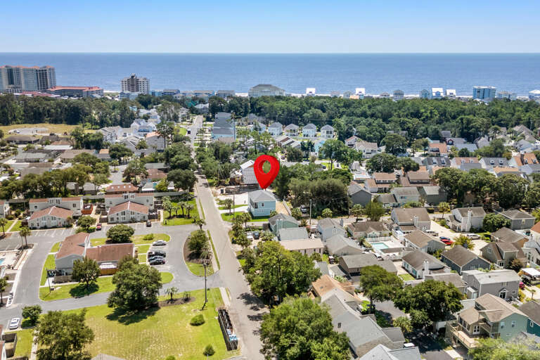 Aerial View Of Suburban Streets Near Sea With Red Marker