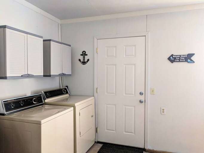 laundry area in garage with door to deck