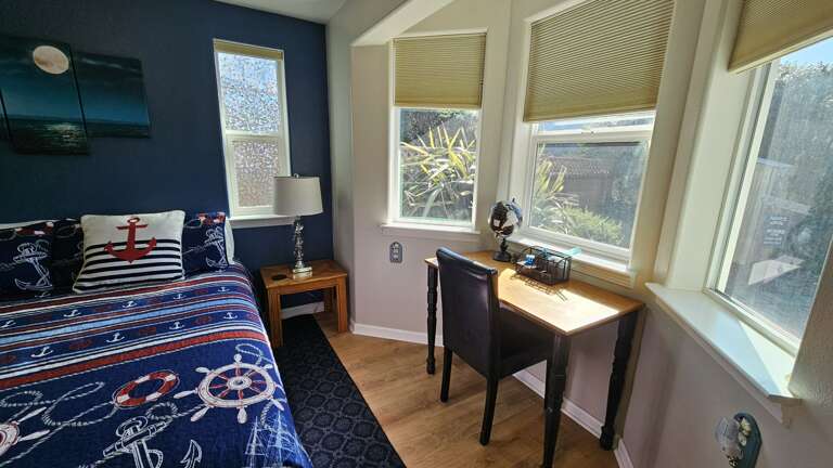Desk in primary bedroom that looks onto backyard garden