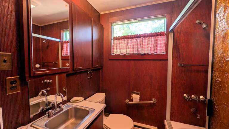 full bathroom with shower/tub combo and retro shower door