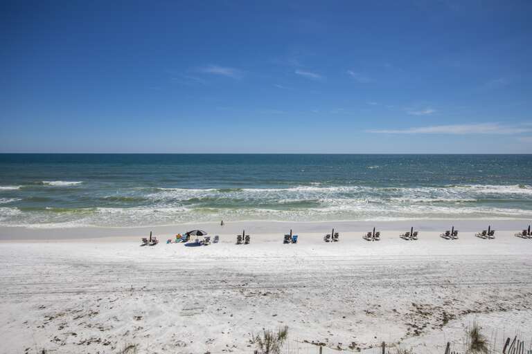 Beachfront Bliss With Blue Skies And Beach Chairs