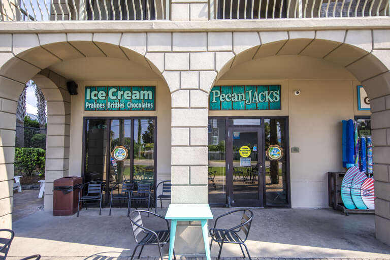 Arched Architecture At A Vacation Rental Plaza Featuring An Ice Cream Shop And Water Sports Gear