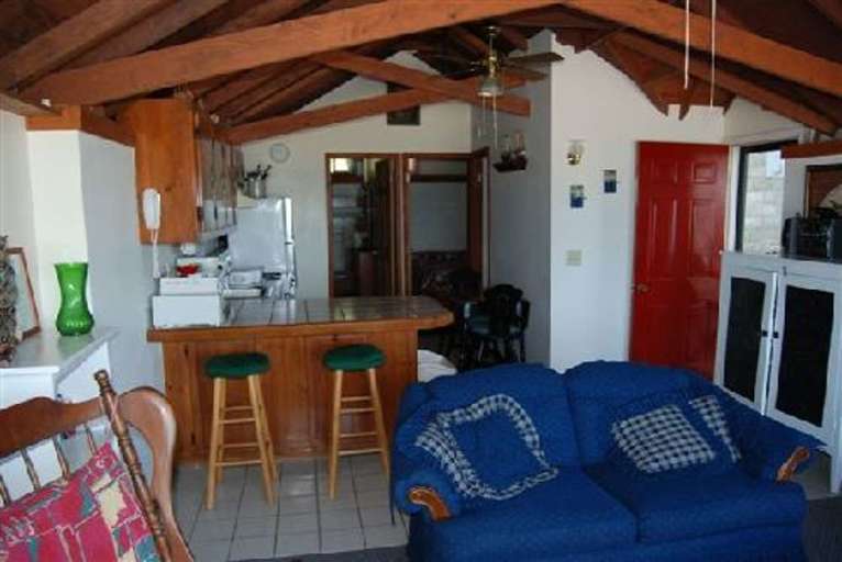 Room With Rustic Beams, Blue Sofa, And Red Door
