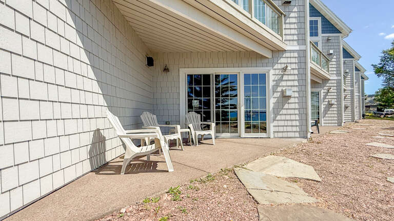 Relax in your private patio with Adirondack chairs and enjoy direct access to the property, framed by classic coastal architecture and open skies.