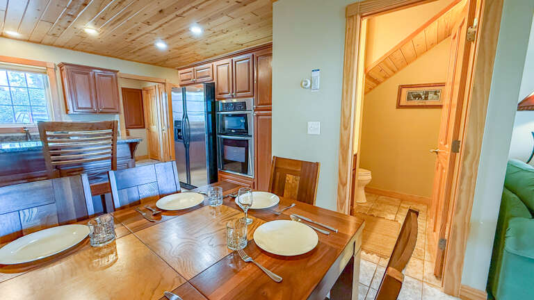 Your open-concept dining and kitchen area features beautiful wood finishes, vaulted ceilings with natural light, and modern stainless appliancesâperfect for gathering around home-cooked meals during your stay.