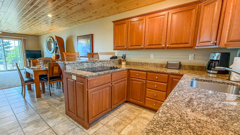 Step into your fully-equipped kitchen with granite counters, rich wood cabinetry, and open flow to the dining areaâready for morning coffee or preparing memorable meals together.