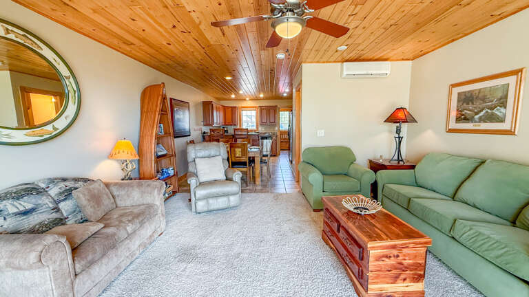 Unwind in your bright open living area with vaulted wood ceilings, plush seating, and warm cabin charm that invites you to settle in and relax.