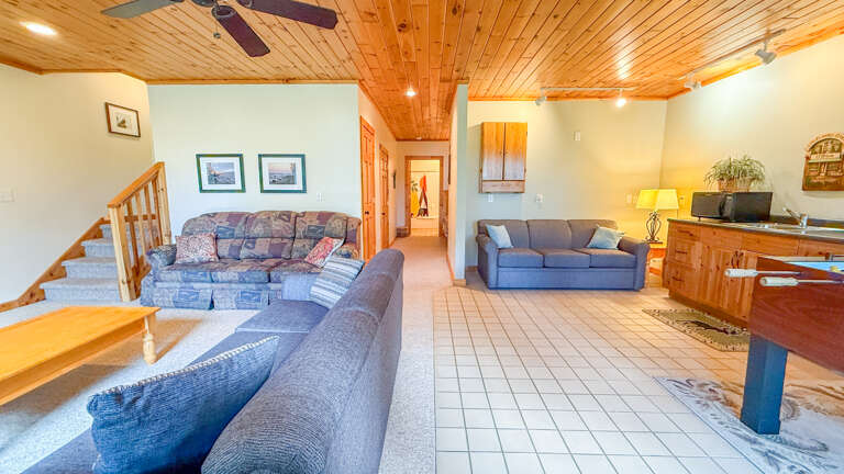 Unwind in your spacious retreat with vaulted wood ceilings, two comfortable sofas, and a cozy ambiance perfect for gathering after mountain adventures.