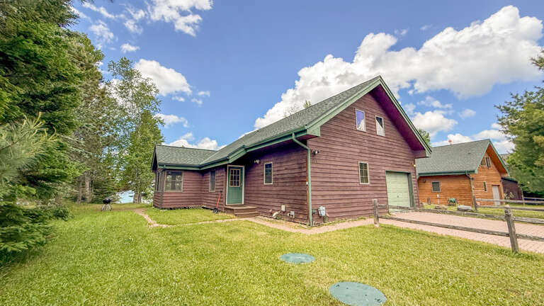 This charming cabin sits nestled among trees with a spacious lawn, offering a peaceful mountain retreat surrounded by natural beauty and fresh air.